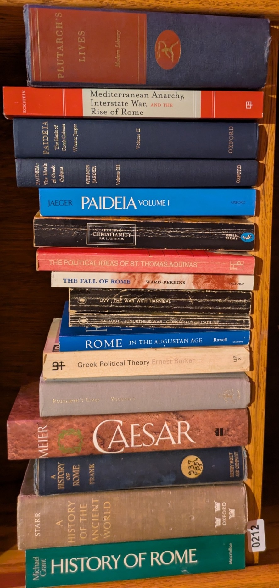 Photograph of Shelf 212; books are listed in top-to-bottom order alongside the photograph.