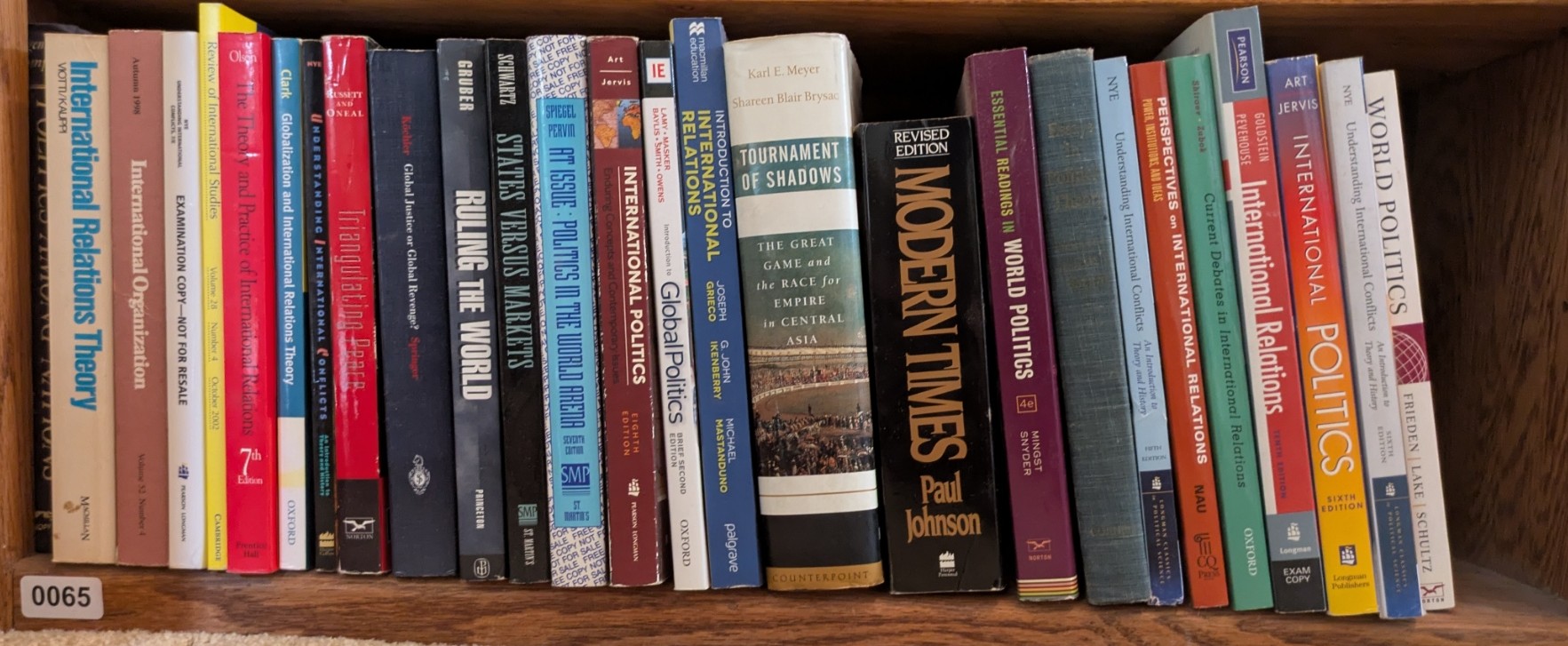 Photograph of Shelf 65; books are listed in top-to-bottom order alongside the photograph.