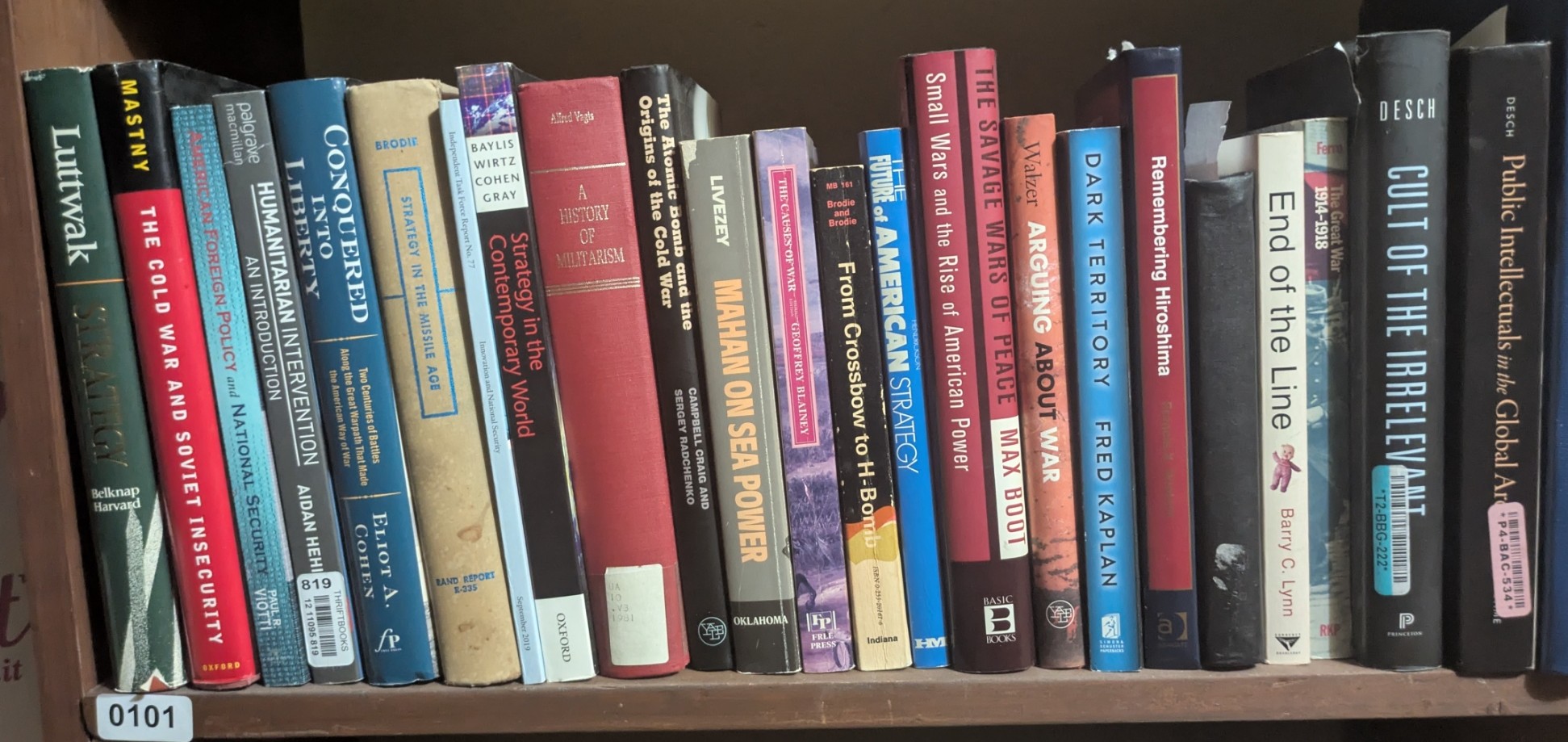 Photograph of Shelf 101; books are listed in top-to-bottom order alongside the photograph.
