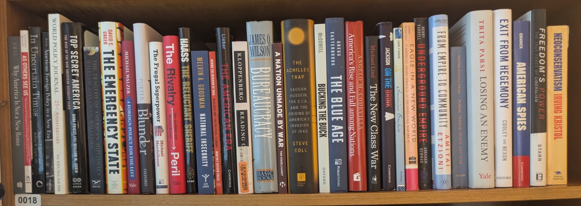 Photograph of Shelf 18; books are listed in top-to-bottom order alongside the photograph.