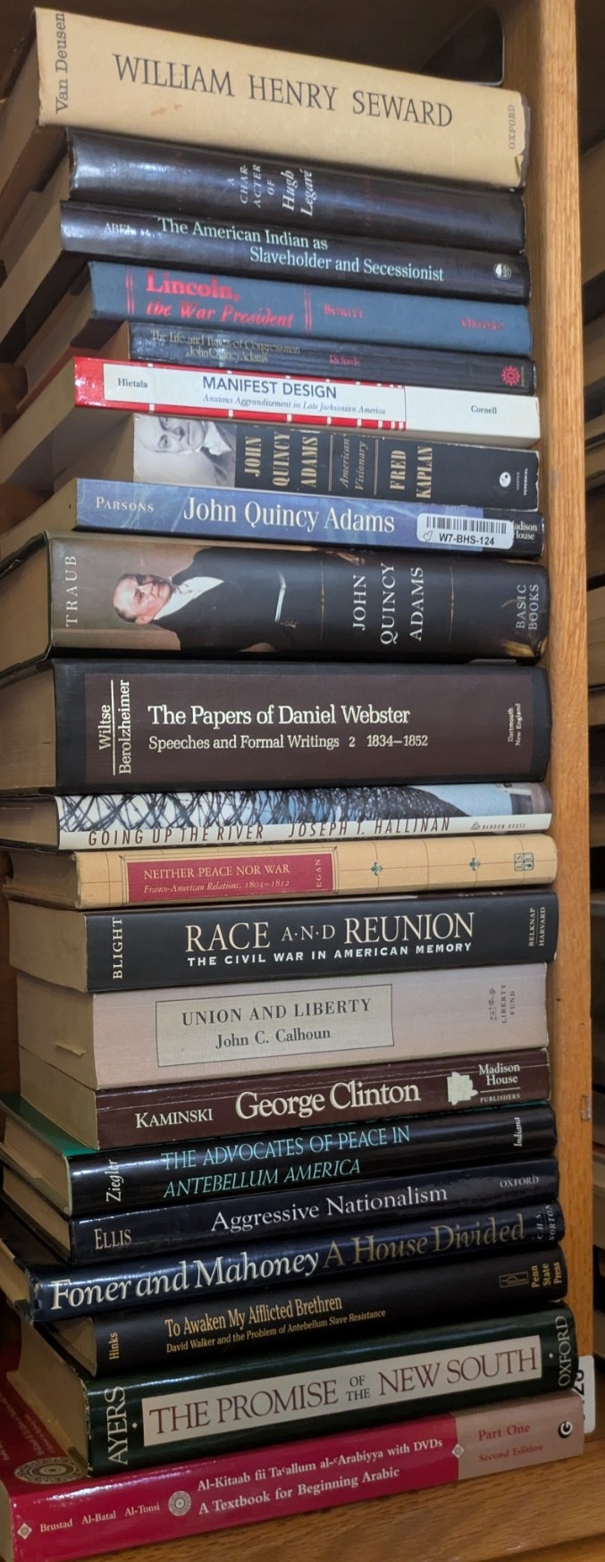 Photograph of Shelf 128; books are listed in top-to-bottom order alongside the photograph.