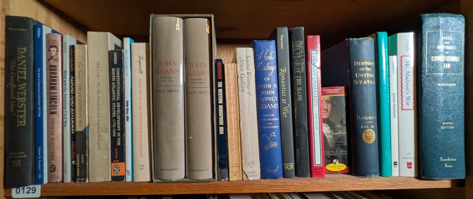 Photograph of Shelf 129; books are listed in top-to-bottom order alongside the photograph.